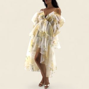 Robe jaune aux tons doux, asymétrique avec une coupe courte devant et longue derrière. Tissu fluide légèrement transparent, doublé sur le corps. Manches tombantes sur les bras et fines bretelles ajustables.